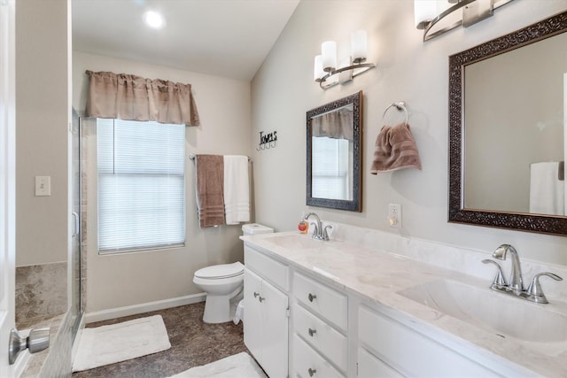 bathroom featuring vanity, a shower with shower door, and toilet