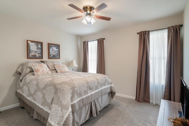 bedroom featuring ceiling fan, light colored carpet, and multiple windows