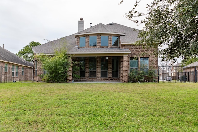 back of house with a yard, brick siding, a chimney, and fence