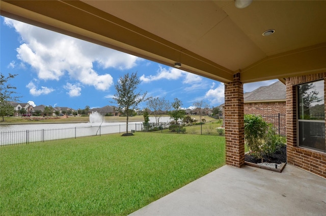 view of yard with a water view and fence