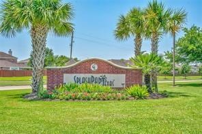 community sign featuring a lawn