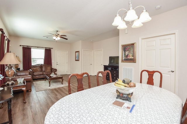 dining room featuring ceiling fan with notable chandelier and hardwood / wood-style floors