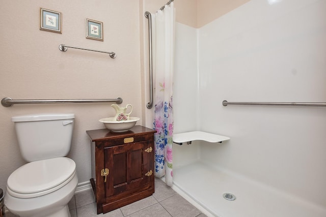 bathroom featuring a shower with shower curtain, tile patterned floors, and toilet