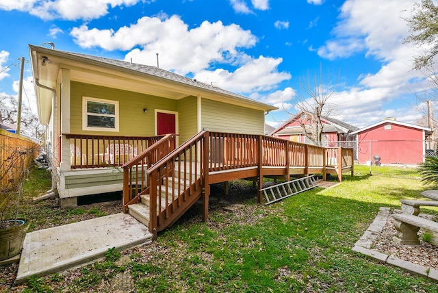 back of property with a wooden deck and a yard