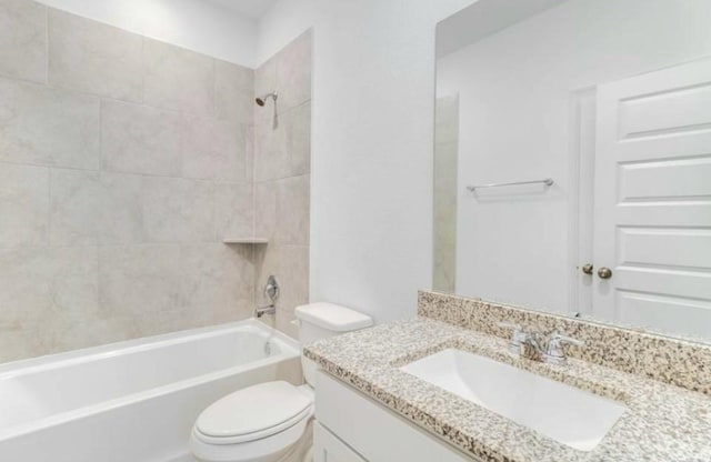 full bathroom with vanity, tiled shower / bath combo, and toilet