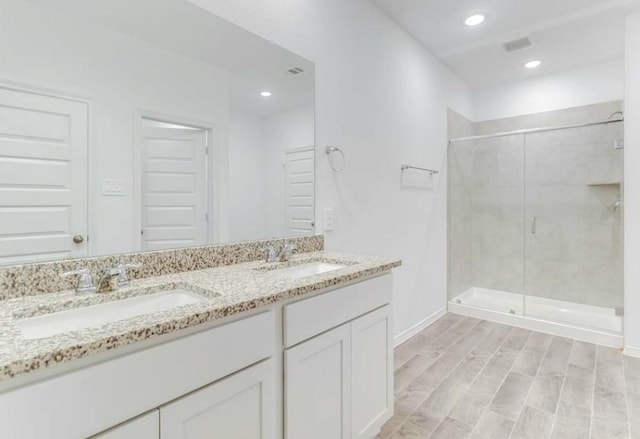 bathroom with a shower with door, vanity, and wood-type flooring