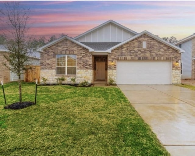 view of front of home with a garage and a lawn