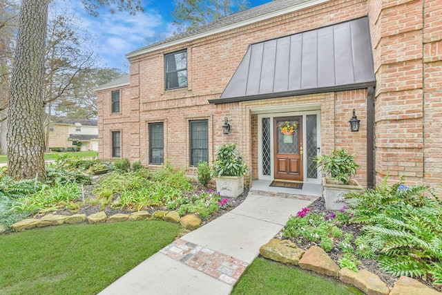 view of exterior entry with a lawn