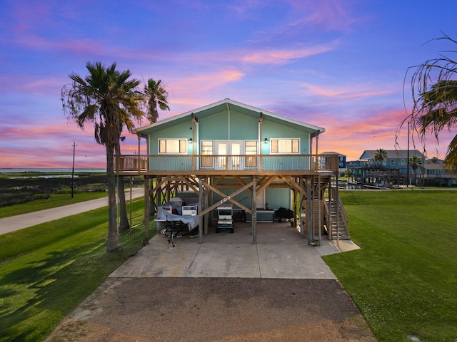 view of front of home featuring a carport, a yard, and covered porch