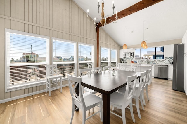 dining area featuring an inviting chandelier, high vaulted ceiling, beamed ceiling, and light wood-type flooring