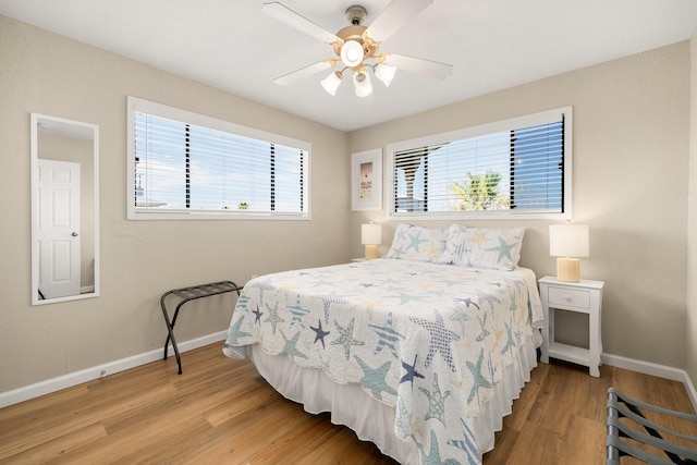 bedroom with multiple windows, light hardwood / wood-style flooring, and ceiling fan