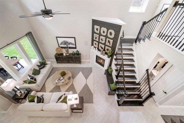 living room with a large fireplace, stairway, and a towering ceiling