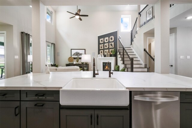 kitchen featuring dishwasher, a high ceiling, open floor plan, and a sink