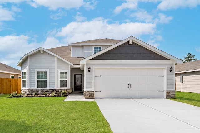 craftsman inspired home with a garage and a front lawn