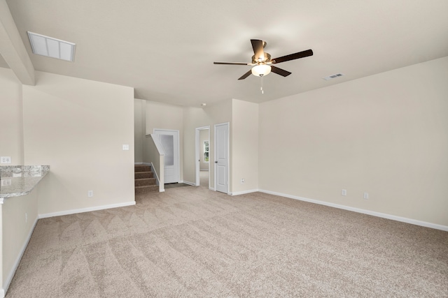 unfurnished living room featuring light colored carpet and ceiling fan