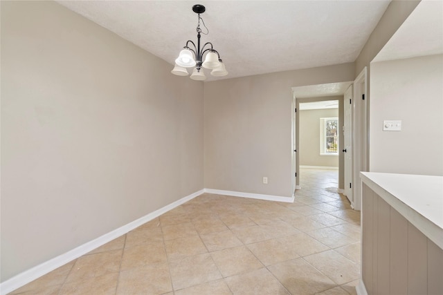 unfurnished room with light tile patterned flooring, a textured ceiling, and a chandelier