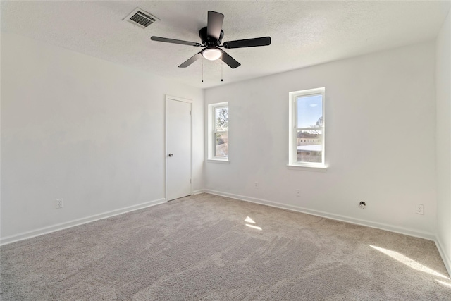 carpeted spare room featuring ceiling fan and a textured ceiling