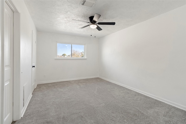 carpeted spare room featuring ceiling fan and a textured ceiling