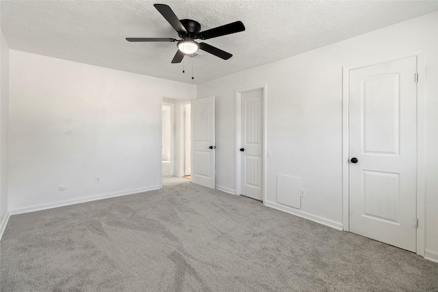 unfurnished bedroom featuring ceiling fan, light colored carpet, and a textured ceiling