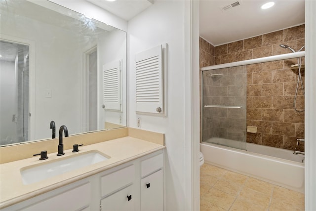 full bathroom featuring toilet, vanity, bath / shower combo with glass door, and tile patterned flooring