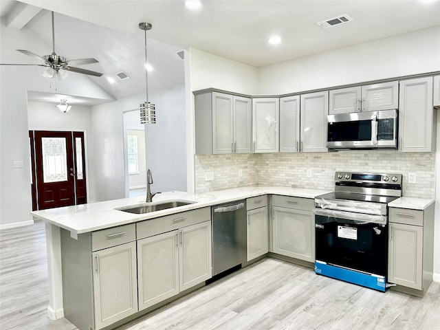 kitchen with pendant lighting, sink, gray cabinetry, stainless steel appliances, and kitchen peninsula