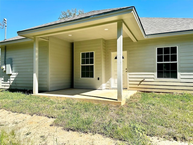 back of house with a lawn and a patio area