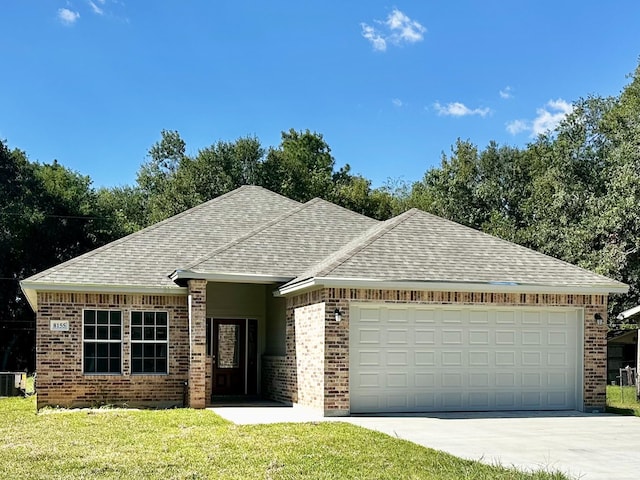 ranch-style home featuring a garage and a front lawn