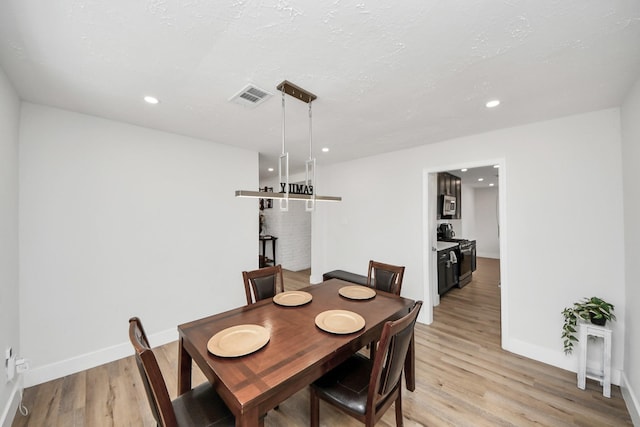 dining area featuring a textured ceiling and light wood-type flooring