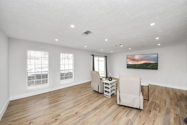 sitting room featuring a textured ceiling and light hardwood / wood-style flooring