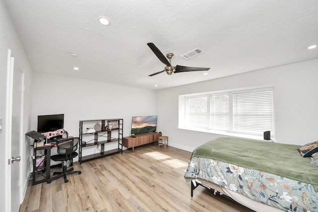 bedroom featuring ceiling fan, a textured ceiling, and light hardwood / wood-style floors