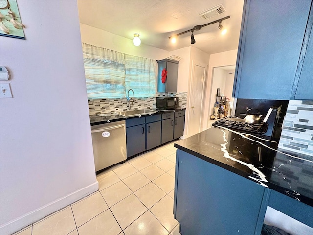 kitchen with sink, light tile patterned floors, blue cabinetry, dishwasher, and tasteful backsplash