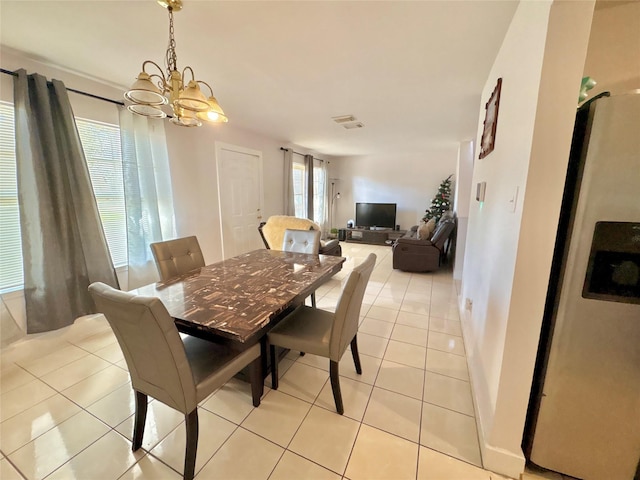 dining area featuring a chandelier and light tile patterned flooring