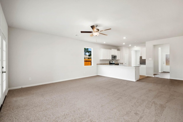 unfurnished living room featuring light carpet and ceiling fan