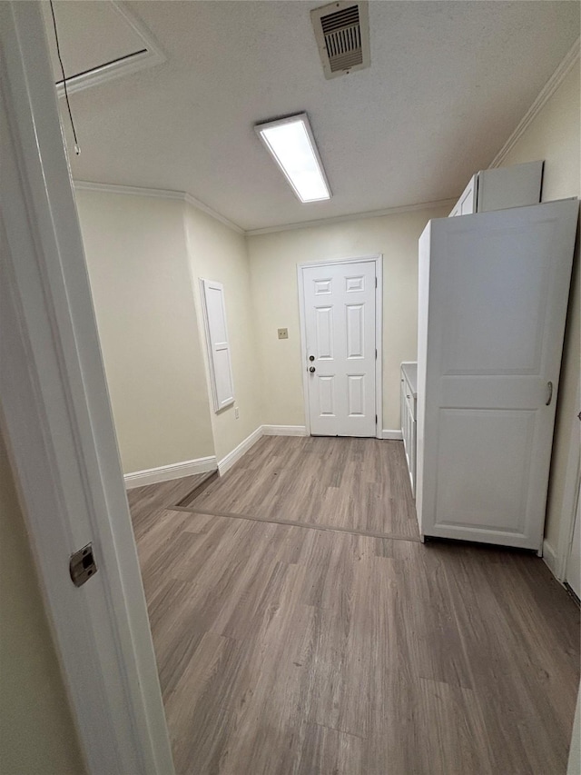 interior space with ornamental molding, light hardwood / wood-style floors, and a textured ceiling