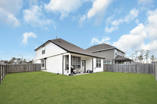 rear view of house featuring a lawn and a patio