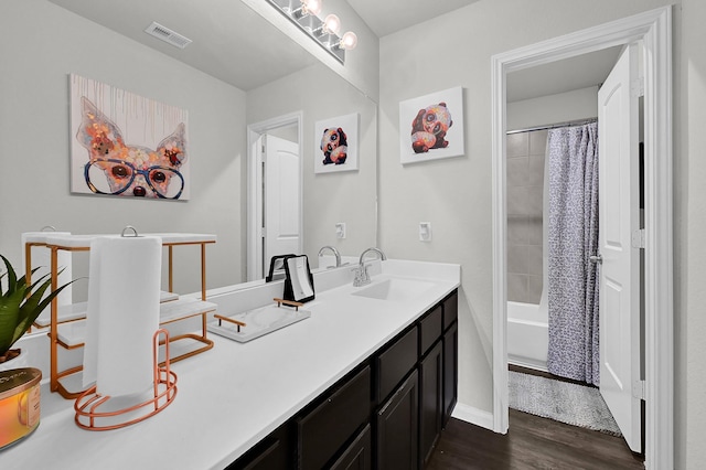 bathroom with vanity, hardwood / wood-style floors, and shower / bath combo