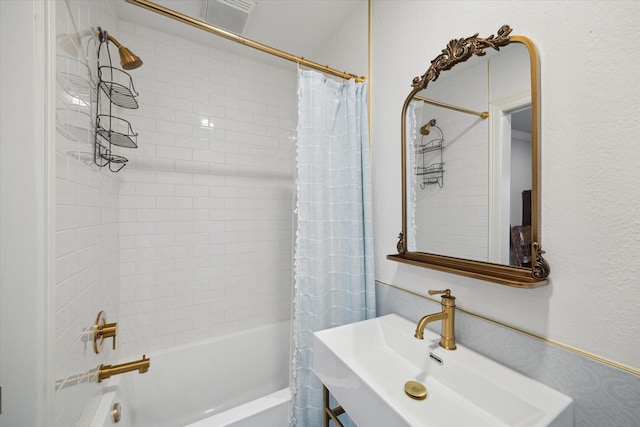 bathroom featuring shower / tub combo with curtain and sink