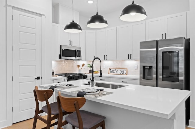 324 Neyland St, Houston, TX 77022 - kitchen with appliances with stainless steel finishes, a sink, decorative backsplash, pendant lighting, and white cabinetry