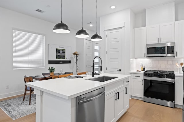 324 Neyland St, Houston, TX 77022 - kitchen featuring appliances with stainless steel finishes, a sink, light wood finished floors, light countertops, and recessed lighting