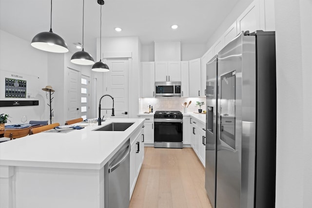 324 Neyland St, Houston, TX 77022 - kitchen featuring stainless steel appliances, a sink, light wood-style floors, white cabinetry, and light countertops