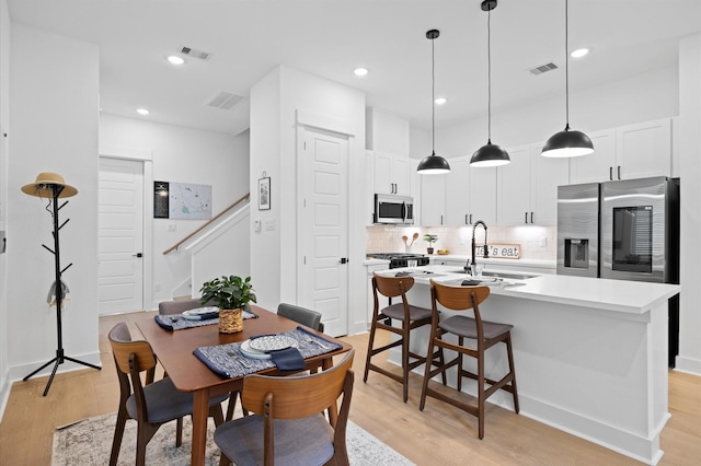324 Neyland St, Houston, TX 77022 - dining space featuring light wood-style flooring, stairway, and recessed lighting