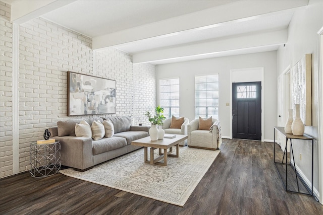 living room featuring beamed ceiling, brick wall, and dark hardwood / wood-style flooring