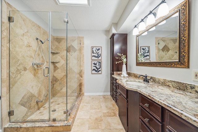 bathroom featuring vanity, a textured ceiling, and walk in shower