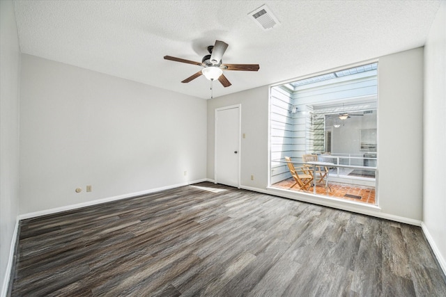 spare room with dark wood-type flooring, a textured ceiling, and ceiling fan