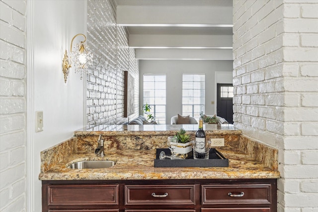 bathroom featuring vanity and brick wall