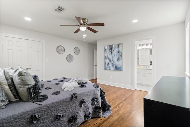 bedroom with hardwood / wood-style floors, ensuite bath, a closet, and ceiling fan