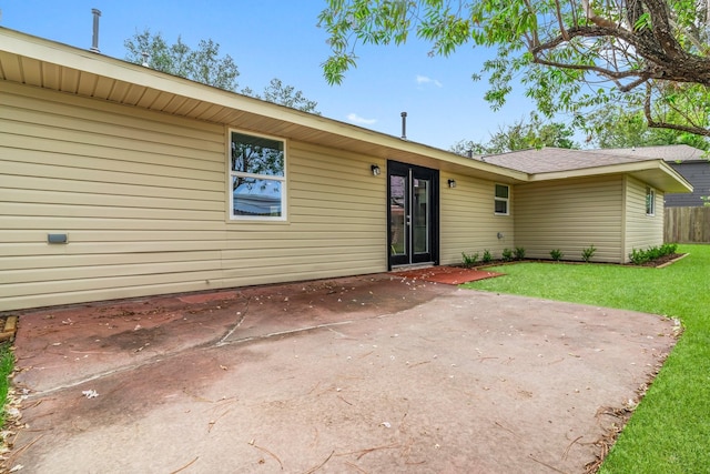 rear view of property with a lawn and a patio area