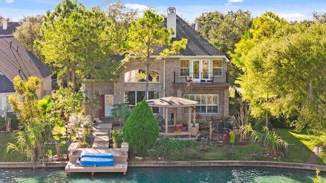 back of property featuring a water view and a balcony