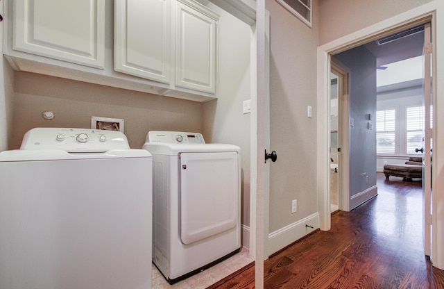 washroom featuring separate washer and dryer, dark wood-type flooring, and cabinets