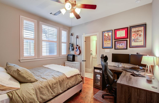 bedroom featuring connected bathroom, hardwood / wood-style flooring, and ceiling fan